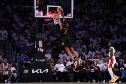 Evan Mobley of the Cleveland Cavaliers dunks the ball against Davion Mitchell in the Cavs'