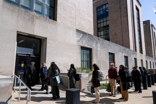 Federal workers wait in line to access to the Mary E. Switzer Memorial Building that house