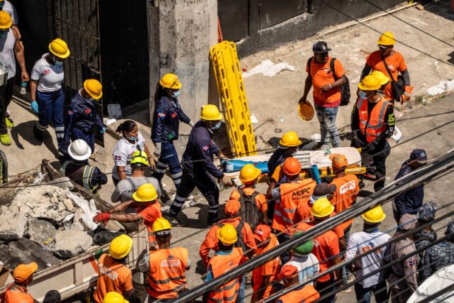 Hundreds of rescue personnel combed mounds of fallen bricks, steel bars and tin sheets for