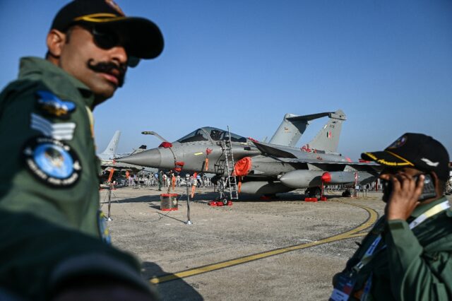 Indian Air Force (IAF) personnel stand in front of a Rafale fighter jet