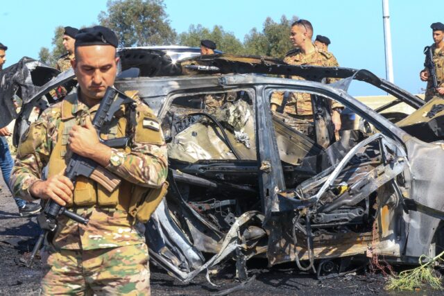 Lebanese soldiers at the site near a burnt-out vehicle in Ghaziyeh, near Sidon -- the heal