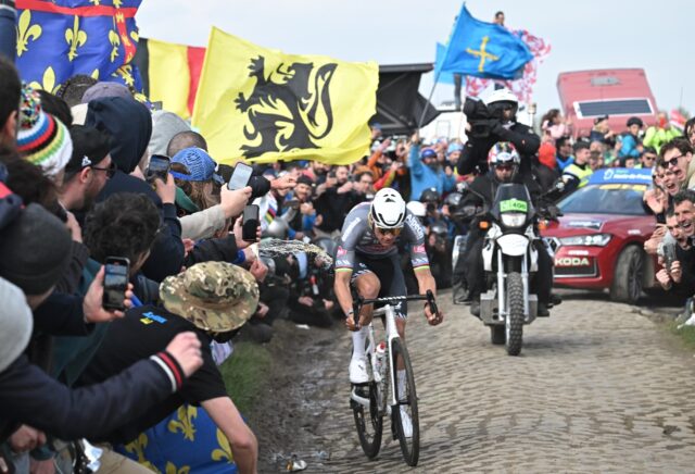 A liquid is spilled as Mathieu van der Poel battles past on the cobbles of Paris-Roubaix