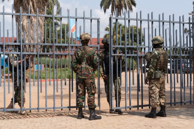 Members of the M23 movement stand at the gate of the local government offices in Bukavu in