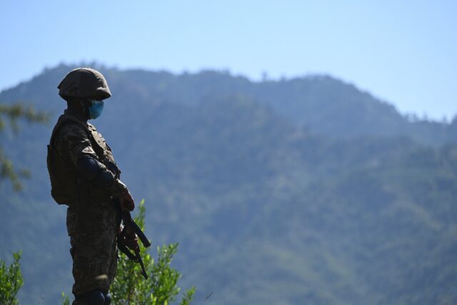 A Pakistani soldier stands guard on a post near the Line of Control between India and Paki