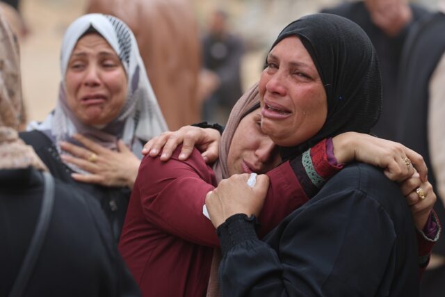 Palestinians mourn during a funeral of relatives killed in an Israeli strike on a school-t