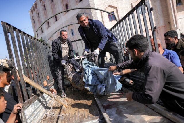 People transport from the bed of a truck the remains of a victim killed in Israeli bombard