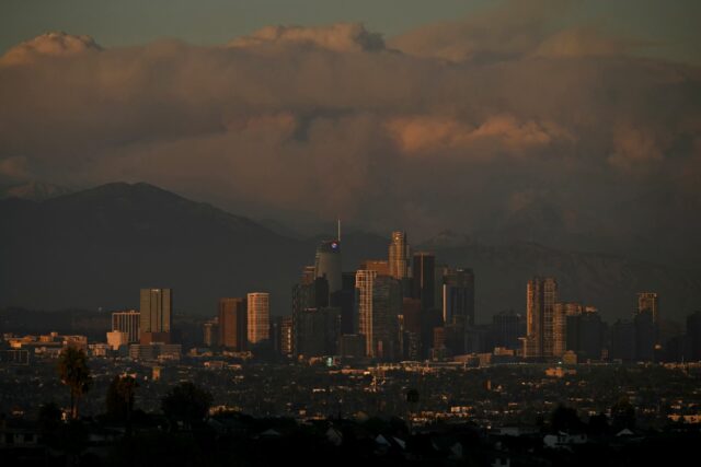 Plumes of smoke from wildfires, including the Bridge Fire, are seen in the mountains behin