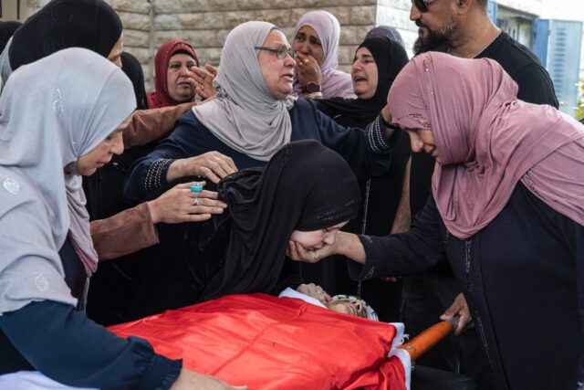 Relatives mourn over the body of 14-year-old Palestinian-American Amer Rabee during his fu