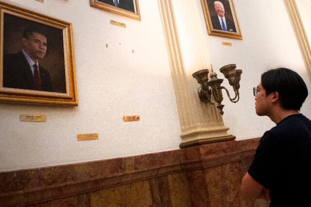 A tourist looks at the empty space where a portrait of US President Donald Trump once hung