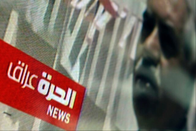 A TV displays the Alhurra Iraq logo in the lobby of the headquarters of the network after