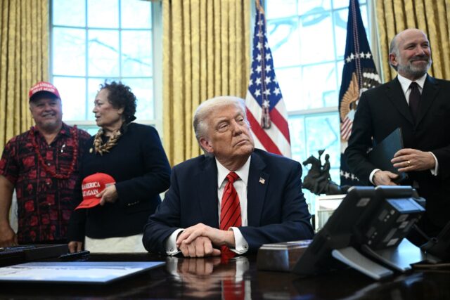 US President Donald Trump and Commerce Secretary Howard Lutnick (R) look on before Trump s