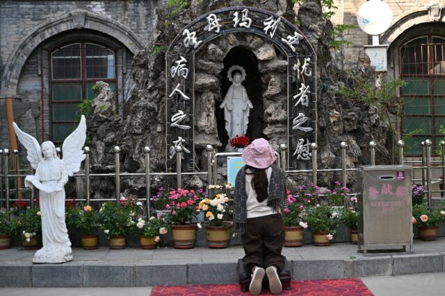 A woman prays outside a Catholic church in Baoding, China’s northern Hebei province
