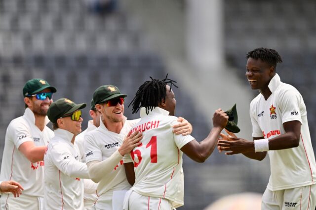 Zimbabwe's Blessing Muzarabani (R) celebrates with his teammates after taking the wicket o