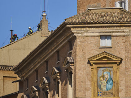 Firefighters place the chimney on the roof of the Sistine Chapel, where cardinals will gat