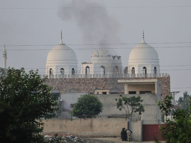 AP25127105584542 Local residents stand outside a mosque of an Islamic seminary partially damaged by a suspe
