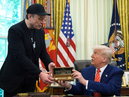 President Donald Trump, right, presents a key to Elon Musk during a news conference in the