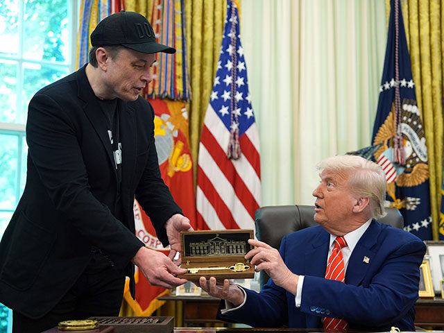 President Donald Trump, right, presents a key to Elon Musk during a news conference in the
