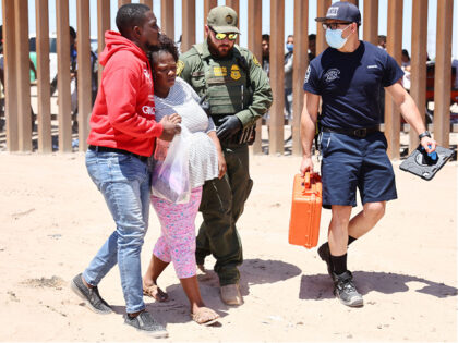 SAN LUIS, ARIZONA- MAY 21: A U.S. Border Patrol agent helps a pregnant immigrant from Hait