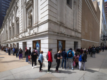 Illinois residents wait in a line that stretches nearly two blocks to enter the Real ID Su