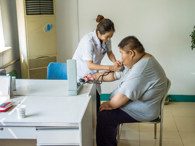 China obesity This picture taken on May 25, 2015 shows a nurse taking the blood pressure of an overweigh