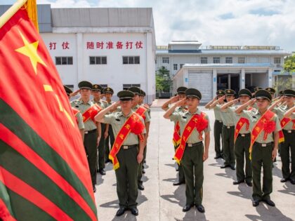 Chinese soldiers salute flag