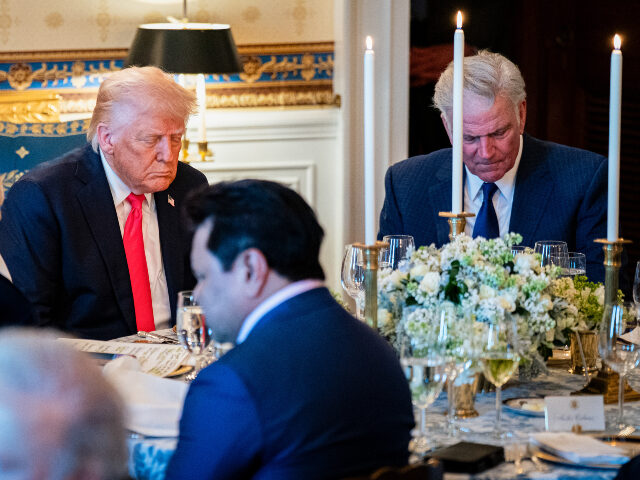 President Donald Trump bows his head during a prayer at an Easter prayer service and dinne