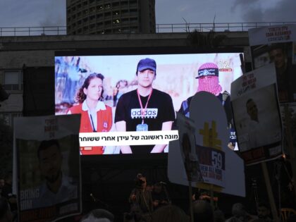People watch a live broadcast of Israeli-American soldier Edan Alexander as he is released