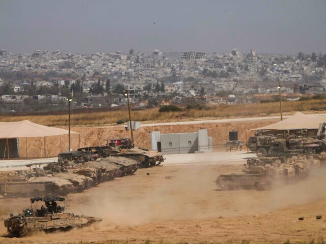 Gaza (Ariel Schalit / Associated Press) Israeli soldiers work on tanks and armored vehicles at a staging area near the border with