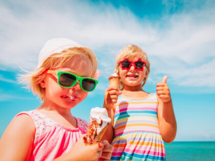 happy cute little girls eating ice cream on beach vacation