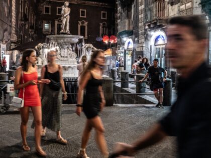 CATANIA, ITALY - JULY 28: Young tourists in front of the ancient Amenano fountain in Piazz