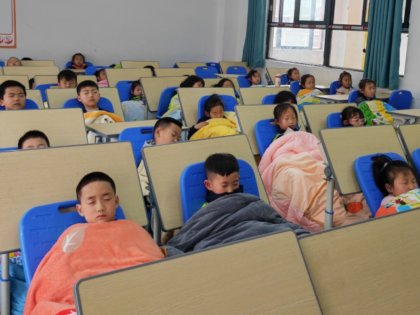 This photo taken with a mobile phone shows students taking noon naps at a classroom of a p