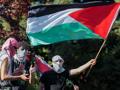 A person waves a Palestinian flag inside an encampment protesting the University of Washin