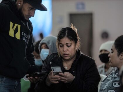20 January 2025, Mexico, Tijuana: Latin American migrants watch the inauguration of US Pre