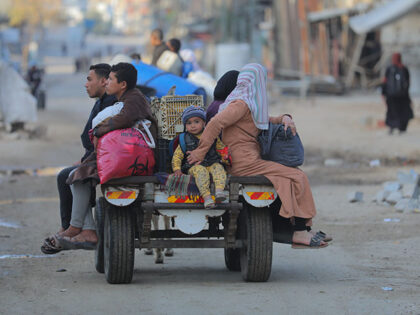 Palestinians in the Al-Mughraqa area of Gaza City, Gaza, travel with what belongings they