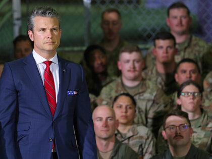 Defense Secretary Pete Hegseth listens as President Donald Trump speaks during a visit wit