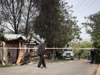 A man stands at a caution tape sealing off a house destroyed by a Russian drone attack in