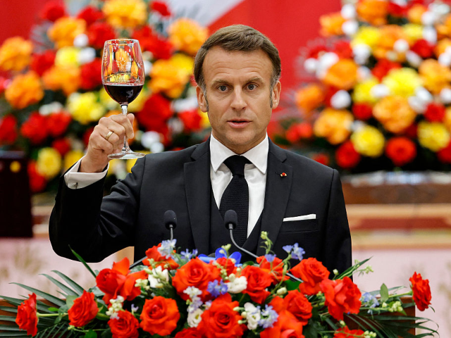 GettyImages-2216546239 France's President Emmanuel Macron raises a toast as he addresses the gathering during a s