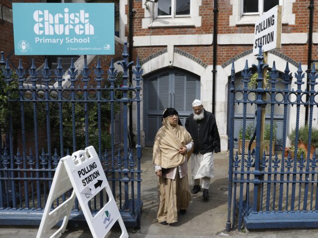 People are pictured outside a polling station on Brick Lane, east London on June 8, 2017,