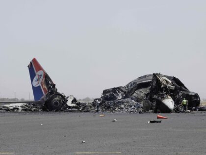 Yemenis inspect wreckage of a destroyed civilian aircraft following Israeli airstrikes on