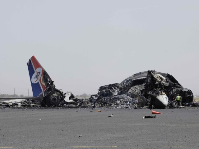 Yemenis inspect wreckage of a destroyed civilian aircraft following Israeli airstrikes on