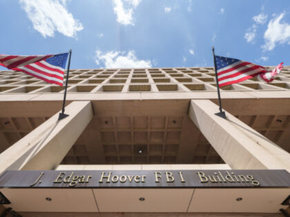 A bronze sign identifies the Federal Bureau of Investigation (FBI) headquarters building o