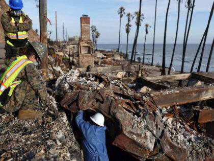 U.S. Marines with the 1st Marine Logistics Group work to remove hazardous waste from a veh
