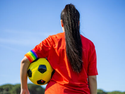 LGBT pride flag on the field. LGBTQ people in sport. - stock photo