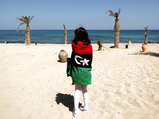 A Libyan girl wrapped with the rebellion flag takes a walk at Regata Beach resort in Tripo