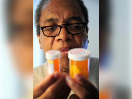 Person Looks at Prescription Drug Bottles Photo by oscar Williams/Peels
