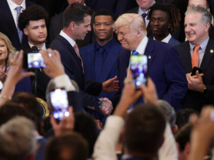 U.S. President Donald Trump shakes hands with Florida Gators head coach Todd Golden (L) du