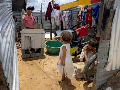 A Venezuelan migrant washes clothes at her home in La Pista migrant camp in Maicao, La Gua