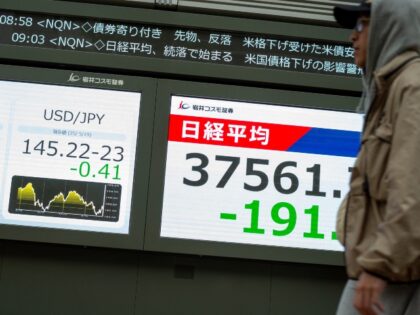 A man walks past electronic boards showing the Japanese yen's rate against the US dol