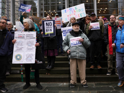 FILE - Martin Bernstein, 95, whose parents were refugees, at center, holds a sign as peopl