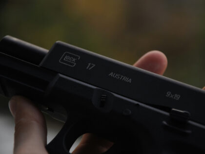 person-holding-black-semi-automatic-pistol